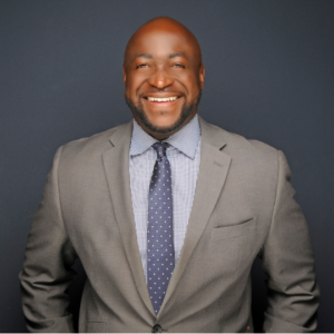 upper body photo of person smiling while wearing a business suit